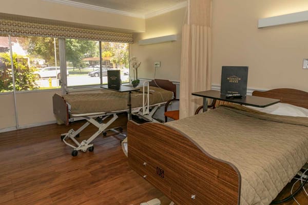 Interior view of a resident room with beds and window