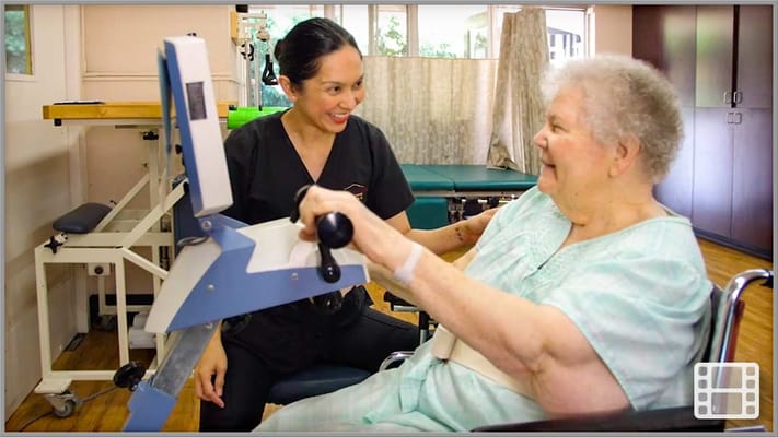 Healthcare staff assisting a resident with therapy equipment