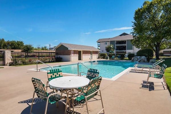 Pool area with lounge chairs and a building in the background