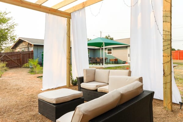 Cozy outdoor lounge with seating and white drapes