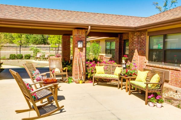 Outdoor seating area with colorful chairs and flowers at Oak Hills Terrace.