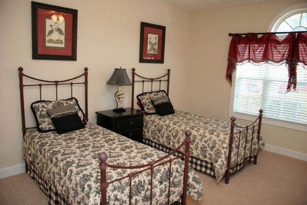 A cozy bedroom with two twin beds and decorative bedding.