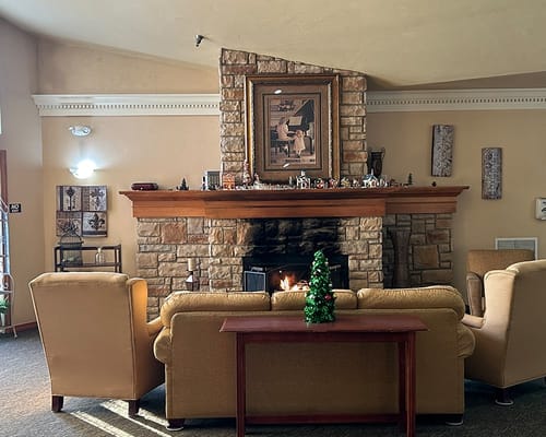 Cozy common area with a stone fireplace and festive decor