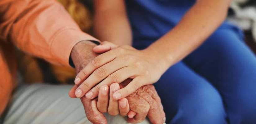 Close-up of hands, showing connection between a caregiver and resident