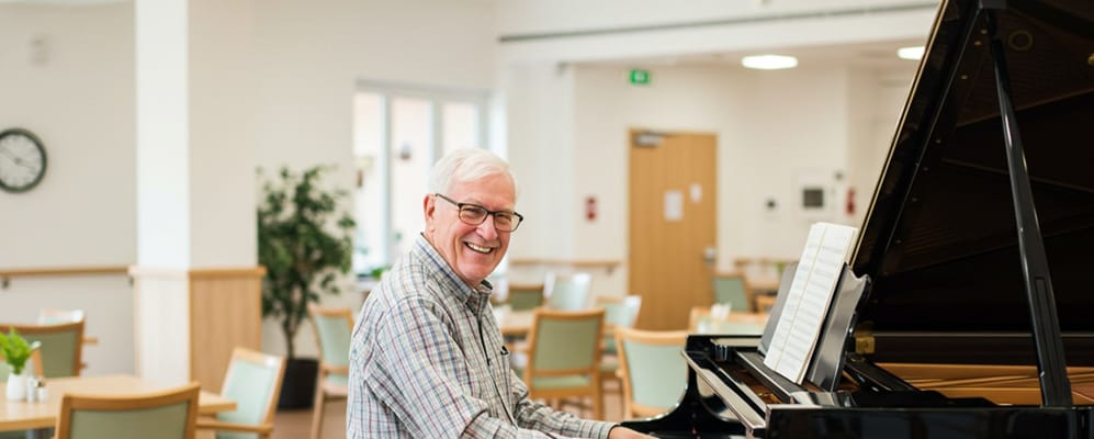 Senior man playing piano in a common area