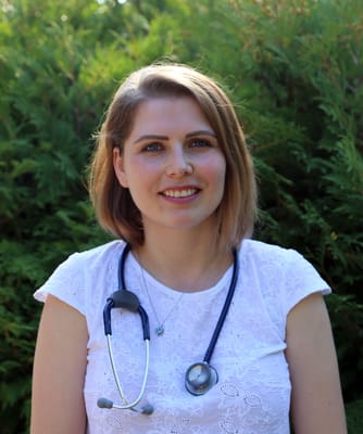 Healthcare worker smiling outdoors with a stethoscope