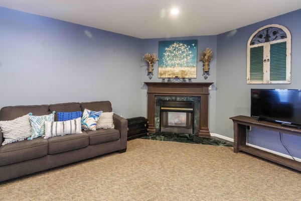 Living room with a sofa, fireplace, and decorative wall art
