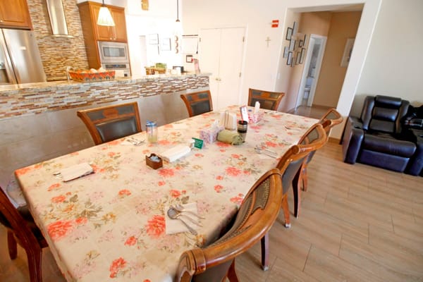 Dining area set up for a meal with floral tablecloth