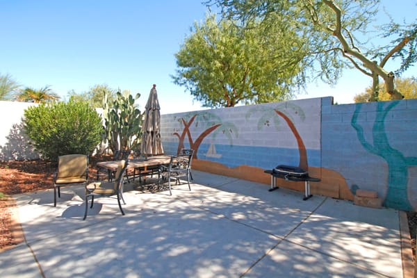 Outdoor seating area with a mural and plants
