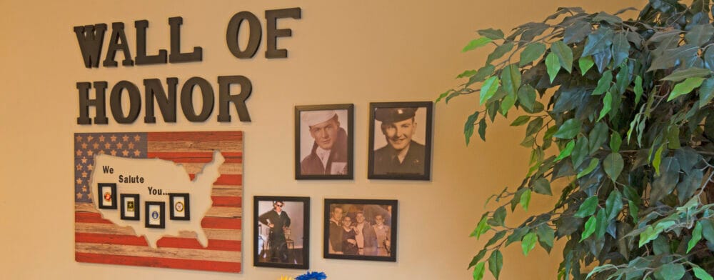Wall of honor displaying framed photographs and decor