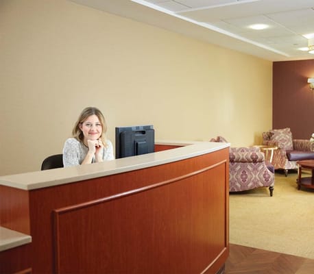 Reception area with staff member smiling