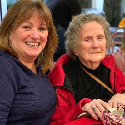 Two women smiling together at a table