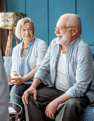 Smiling seniors engaged in conversation in a cozy setting