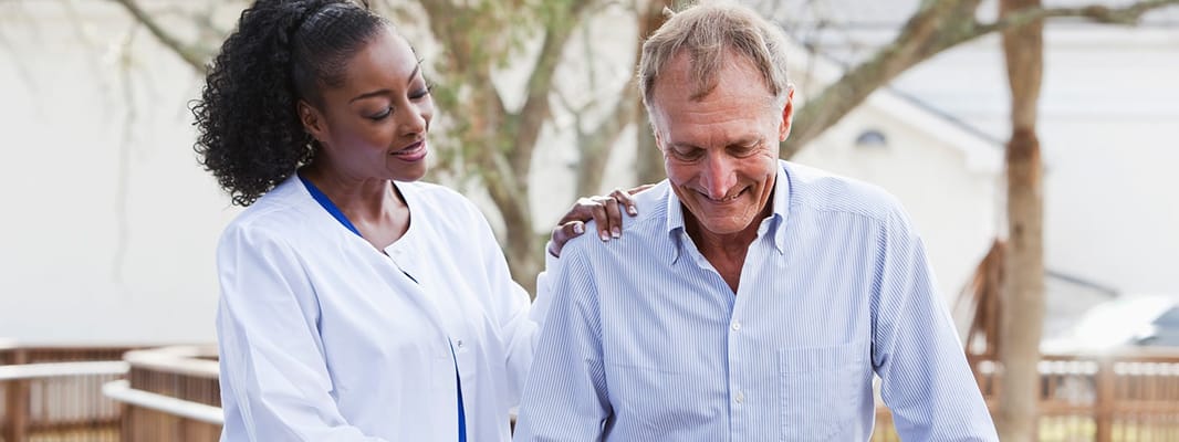 Caregiver assisting a senior resident outdoors