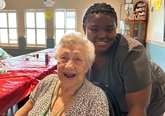 Staff member smiling with a resident in a common area