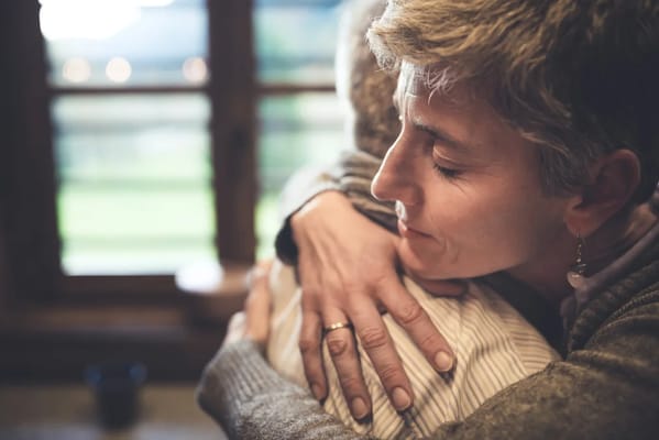 A caregiver embracing a senior resident in a warm setting