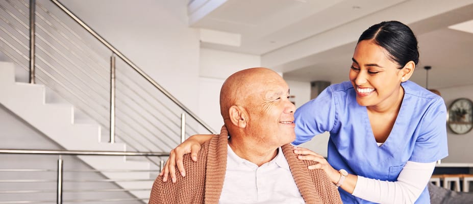 A caregiver smiling with an elderly resident in a facility interior