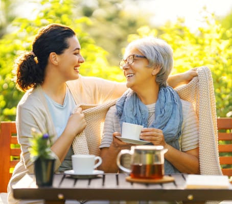 Two women enjoying tea in a garden