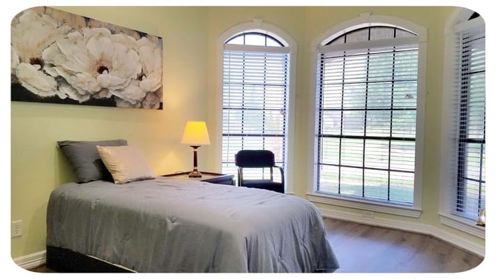 Bright, serene bedroom with a bed and artwork