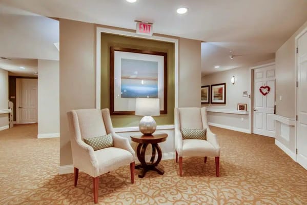 Two chairs and a small table in a lobby area