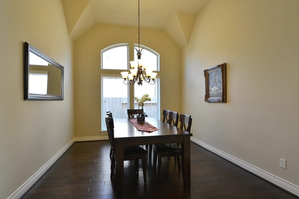 Bright dining area with large windows and chandelier