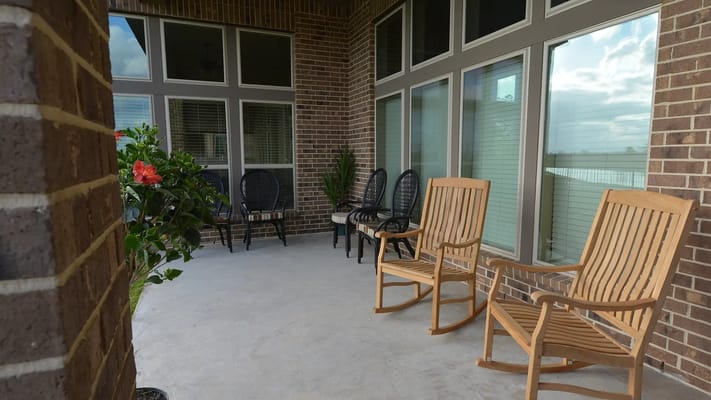 Covered outdoor seating area with chairs and plants