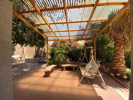Shaded patio with benches and plants at Orange Garden Assisted Living