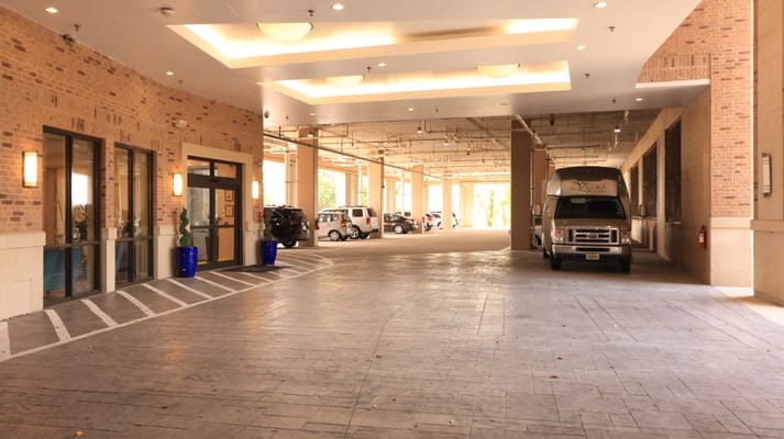 Covered entrance area with vehicles and seating