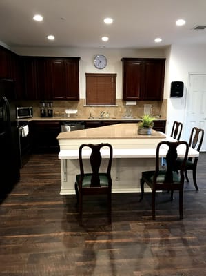 Bright kitchen area with dark wood cabinets and seating