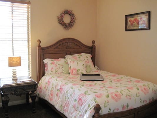 A beautifully decorated bedroom with floral bedding and a cozy ambiance.