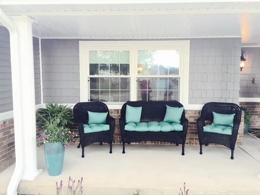 Cozy outdoor seating area with black chairs and teal cushions