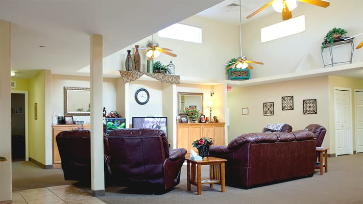 Cozy living room area with leather couches and a clock.