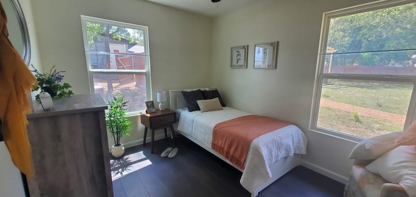Cozy bedroom featuring a single bed, bedside table, and window view