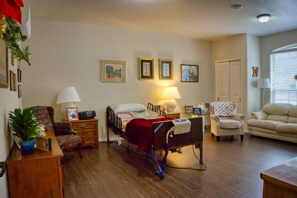 A cozy resident room with a bed and seating area