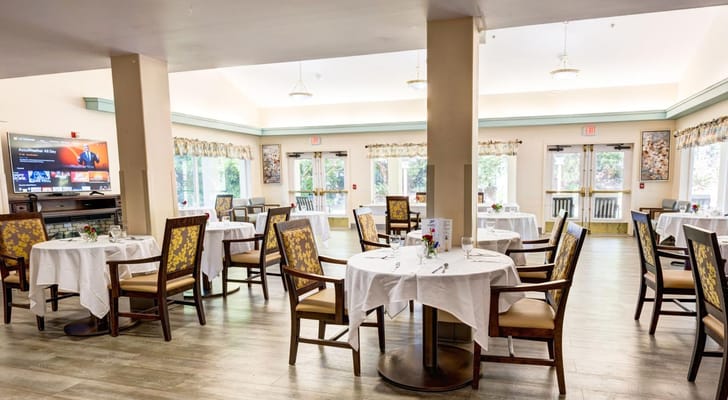 Dining room setup with tables and chairs in a bright space