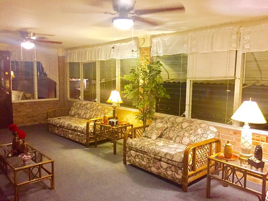 Cozy interior seating area with floral couches and lamps