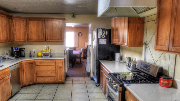 Bright kitchen area with wooden cabinets and a dining space visible