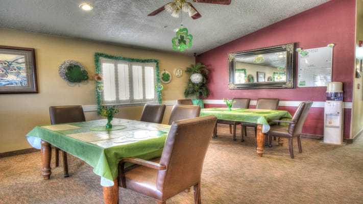 Dining area decorated for a celebration with green tablecloths