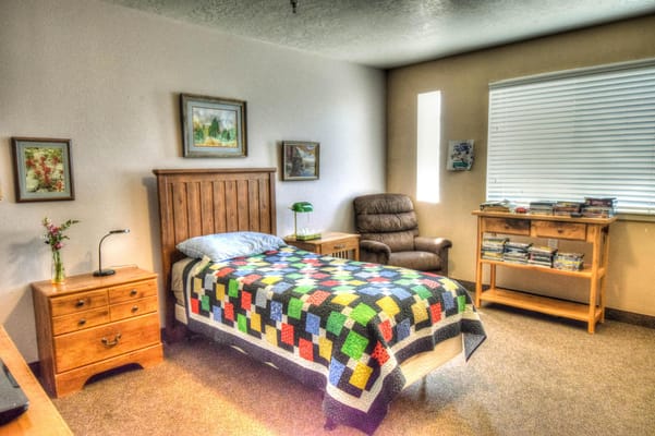 Cozy private resident room with a colorful quilt