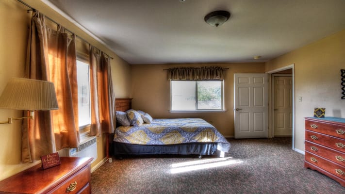 Interior view of a private resident room with a bed and dresser
