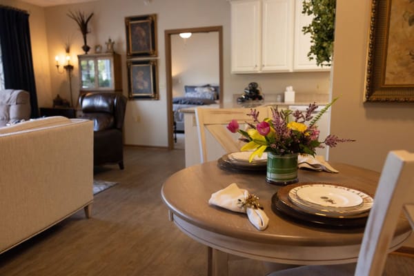 Cozy dining area featuring a table set with plates and a floral arrangement.