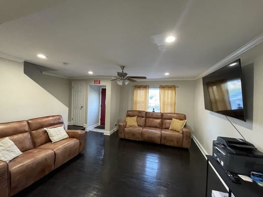 Cozy living room with two brown sofas and a TV