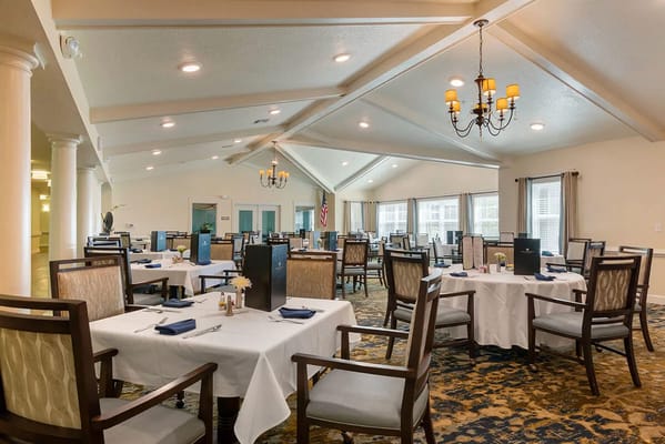 Elegant dining room with tables set for residents.