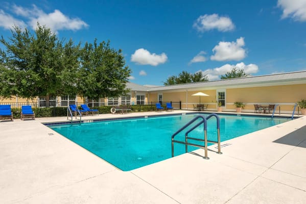 Swimming pool with lounge chairs and umbrellas at The Brennity at Tradition