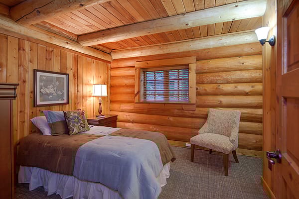 A cozy interior view of a log cabin bedroom
