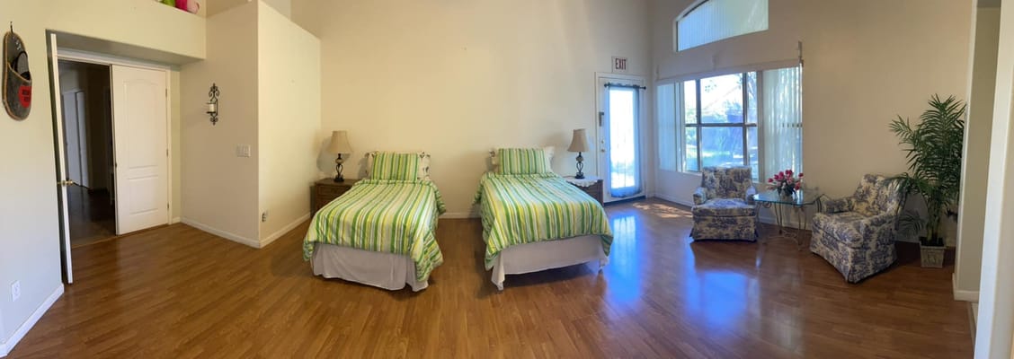 Bright, spacious bedroom with two twin beds and seating area