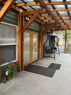 Covered patio area with a swing and flower pot