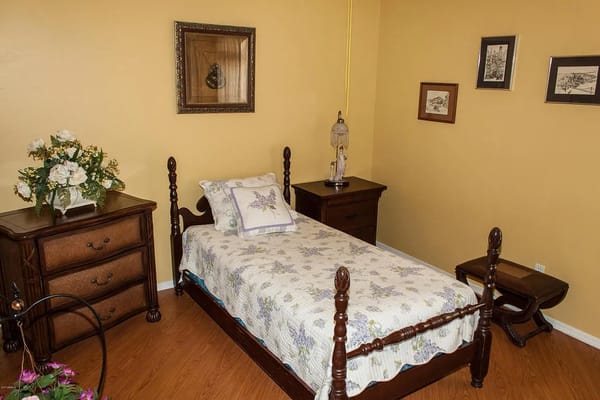 Cozy bedroom with floral bedding and wooden furniture
