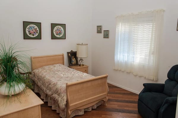 A simple bedroom with a bed and decorative wall art