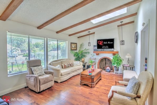 Comfortable living room with large windows and wooden beams.